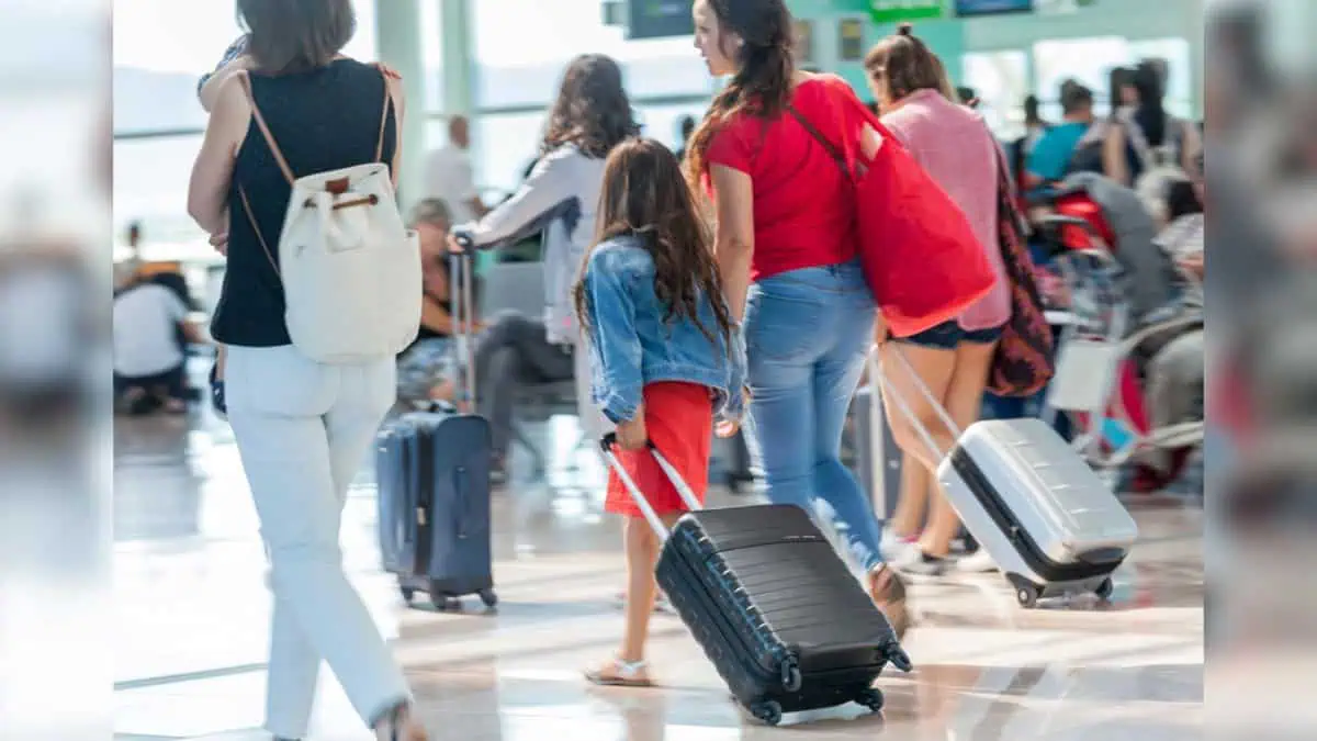 People-carrying-suitcases-and-backpacks-walking-towards-the-departure-gates-at-the-airport